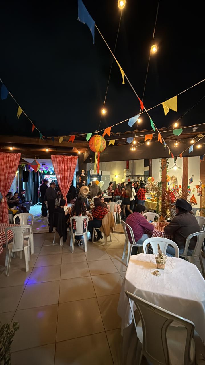 Área coberta do Espaço Meneghelli decorada para festa junina, com balão colorido e luzes