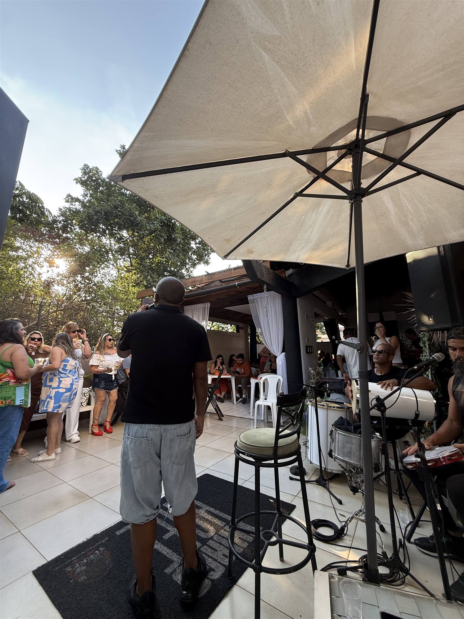 Convidados em pé assistindo à roda de samba no Espaço Meneghelli